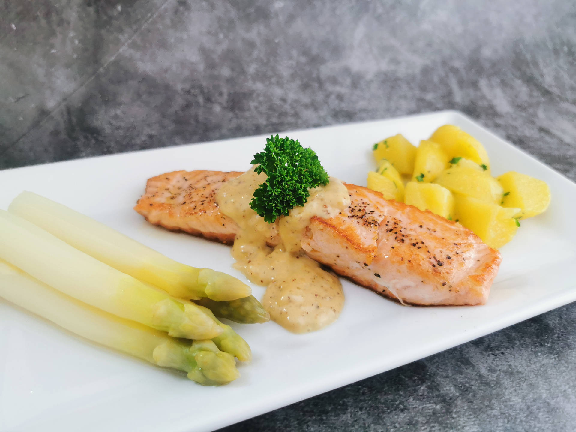 Lachsfilet mit Spargel und Petersilkartoffeln an einer Honig Senf Sauce